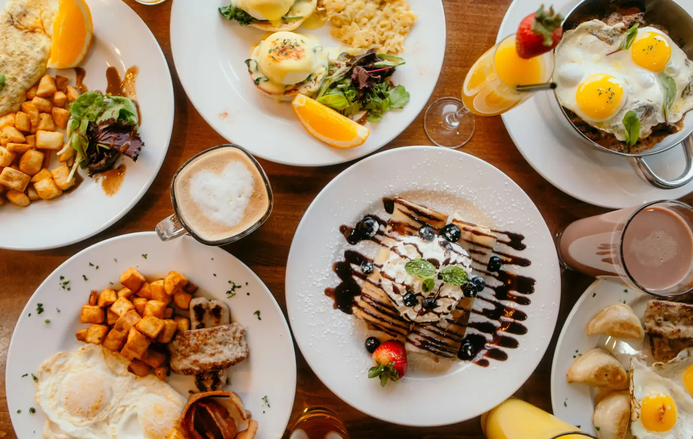Varied breakfast dishes on wooden table — desktop and phone wallpaper, free download