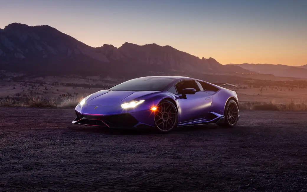 Purple Lamborghini Huracán parked at sunset — desktop and phone wallpaper, free download