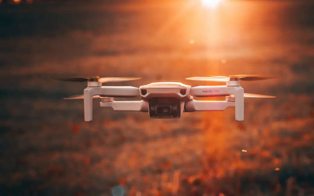 Дрон DJI Mavic Mini летит над полем — обои на рабочий стол и телефон