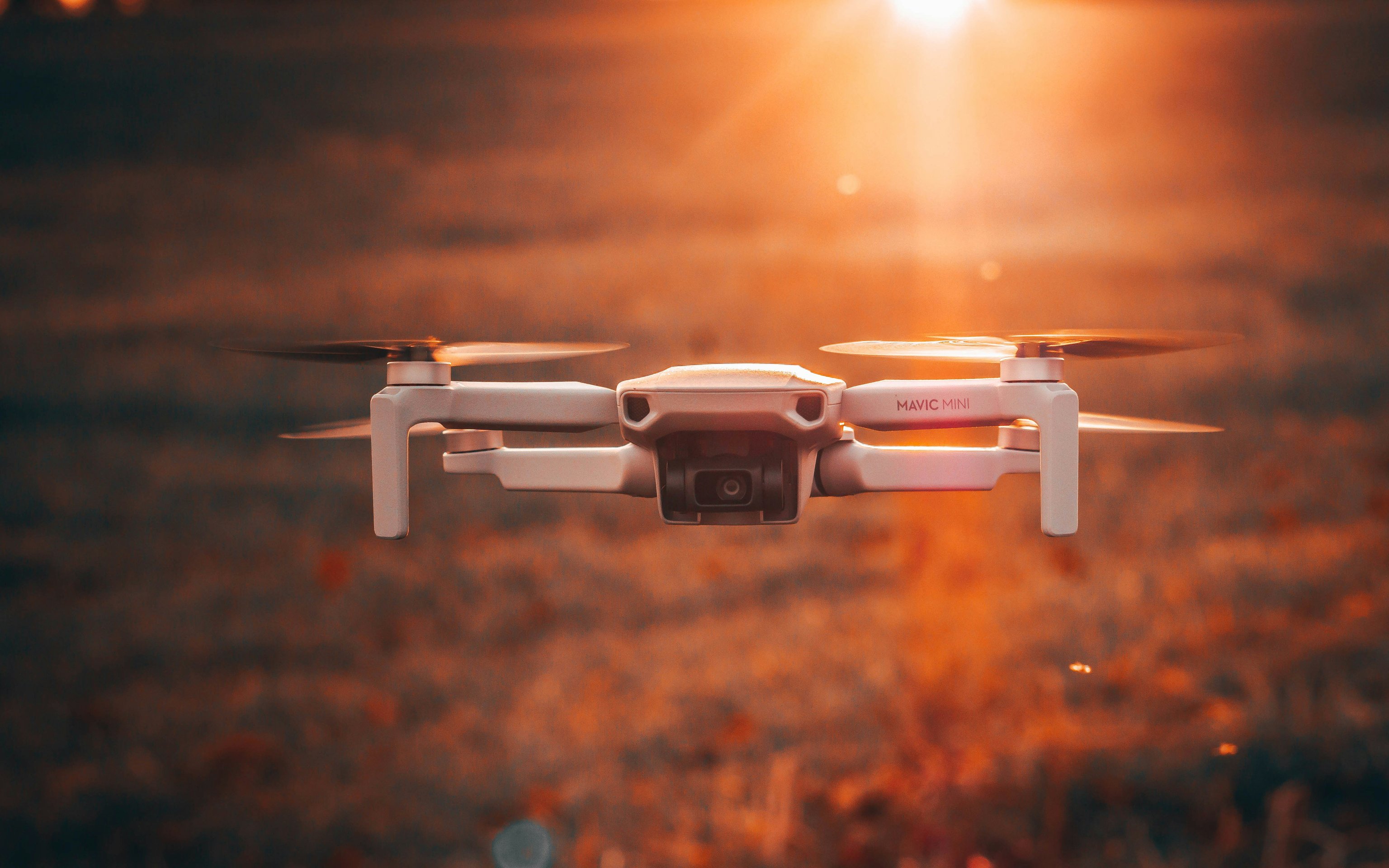 Дрон DJI Mavic Mini летит над полем - Обои для Apple MacBook 16″ в разрешении 3072x1920