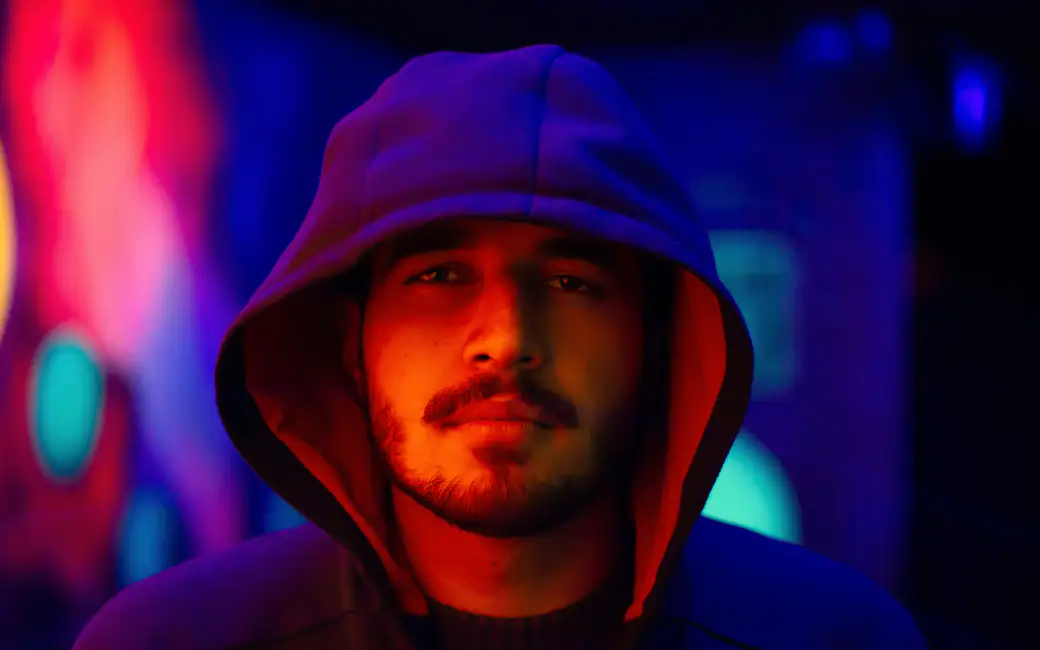 Man in a hoodie in a neon light — desktop and phone wallpaper, free download