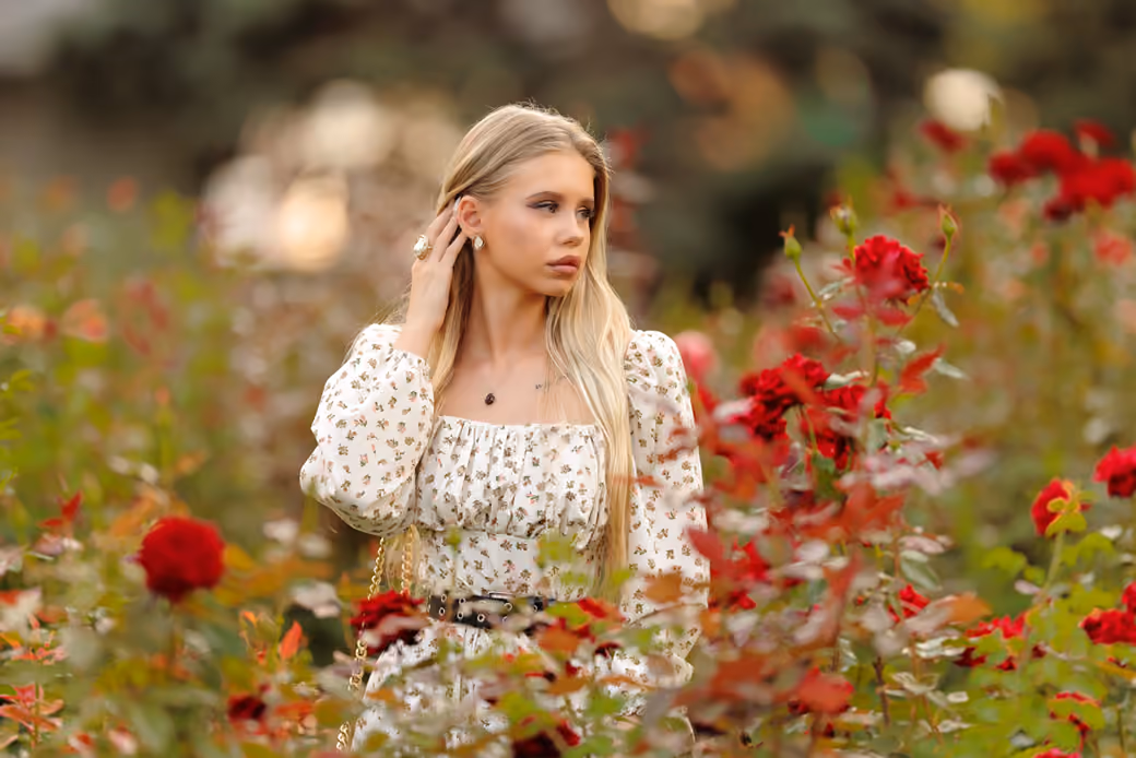 Young blonde among red roses — desktop and phone wallpaper, free download