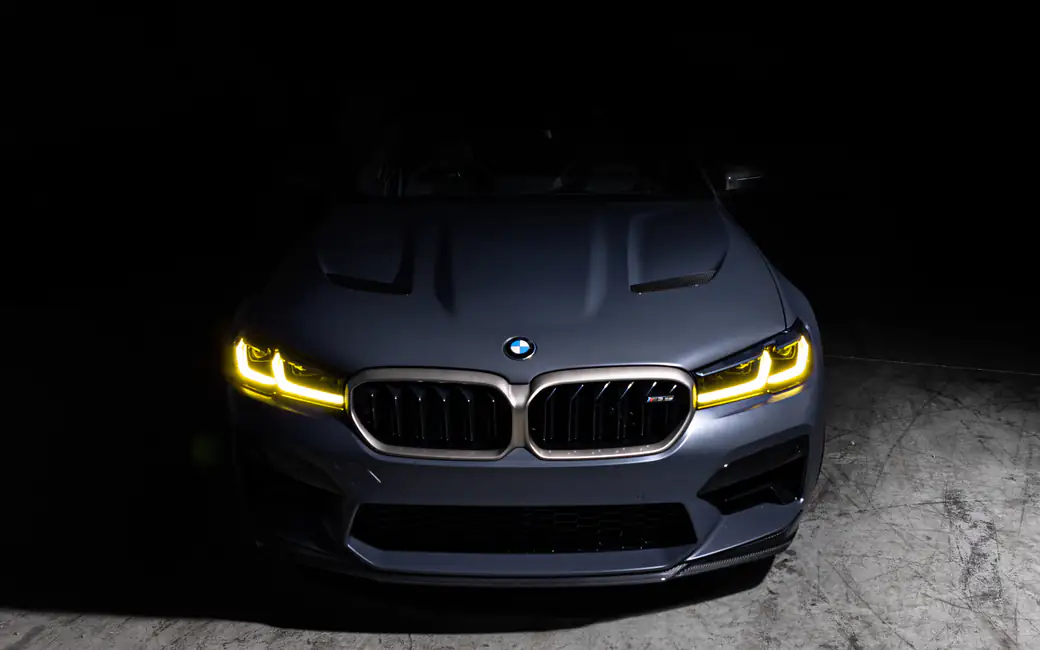 BMW M5 CS F90 with yellow headlights — desktop and phone wallpaper, free download