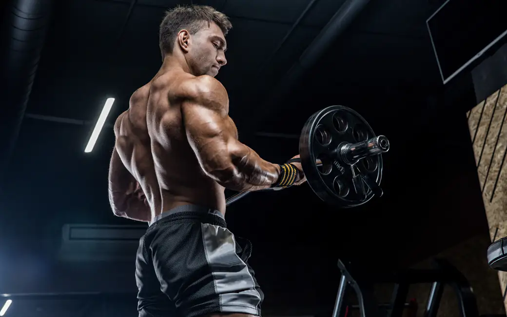 Muscular bodybuilder lifting barbell — desktop and phone wallpaper, free download