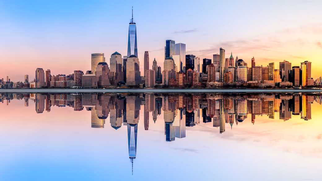 New York is reflected in the river at sunset — desktop and phone wallpaper, free download