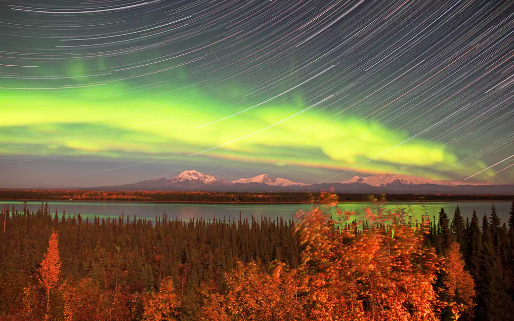 Aurora and light trails over the mountains — desktop and phone wallpaper, free download