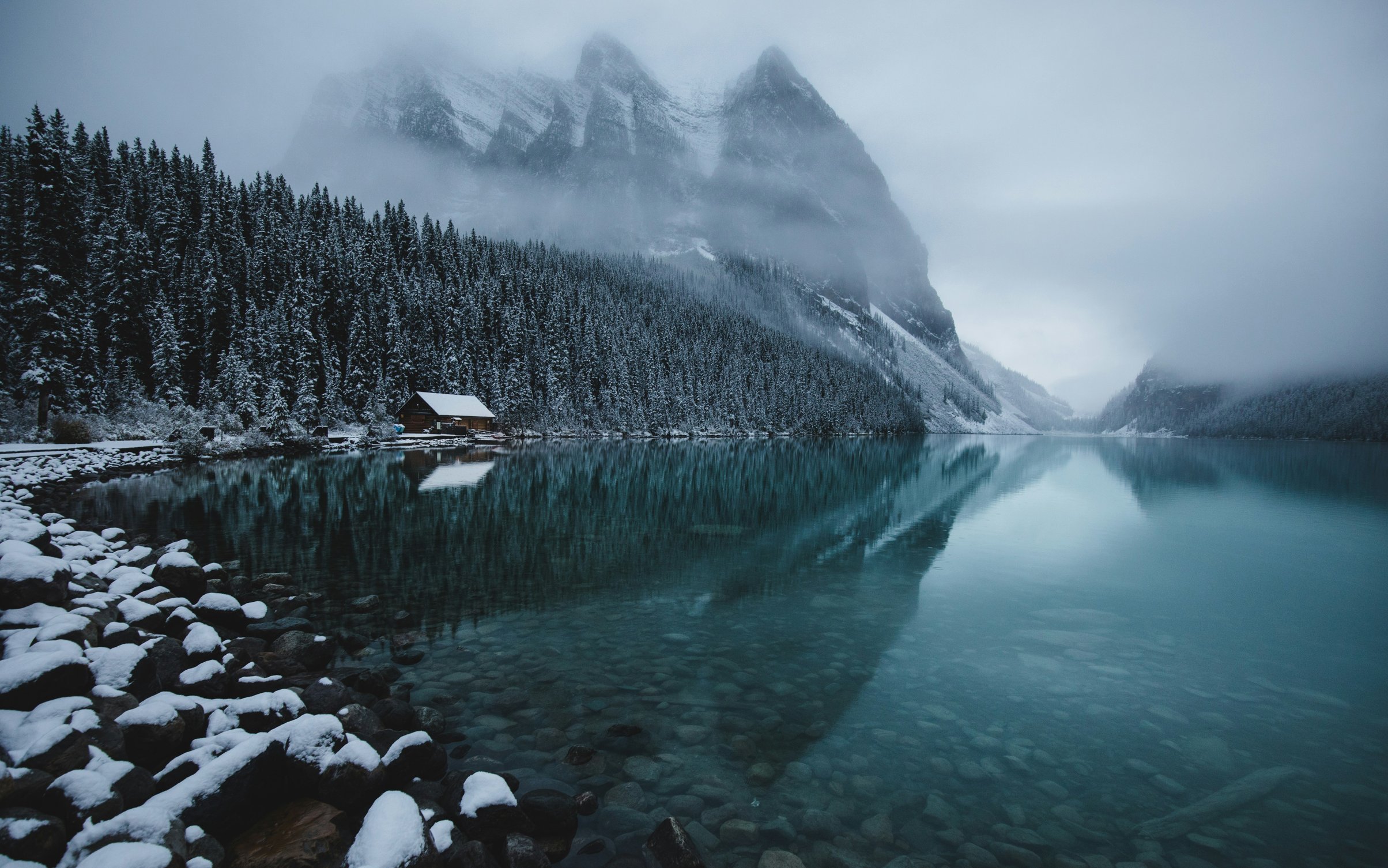 Snowy cabin by mountain lake - Wallpapers for MacBook Neo in 2408x1506 resolution