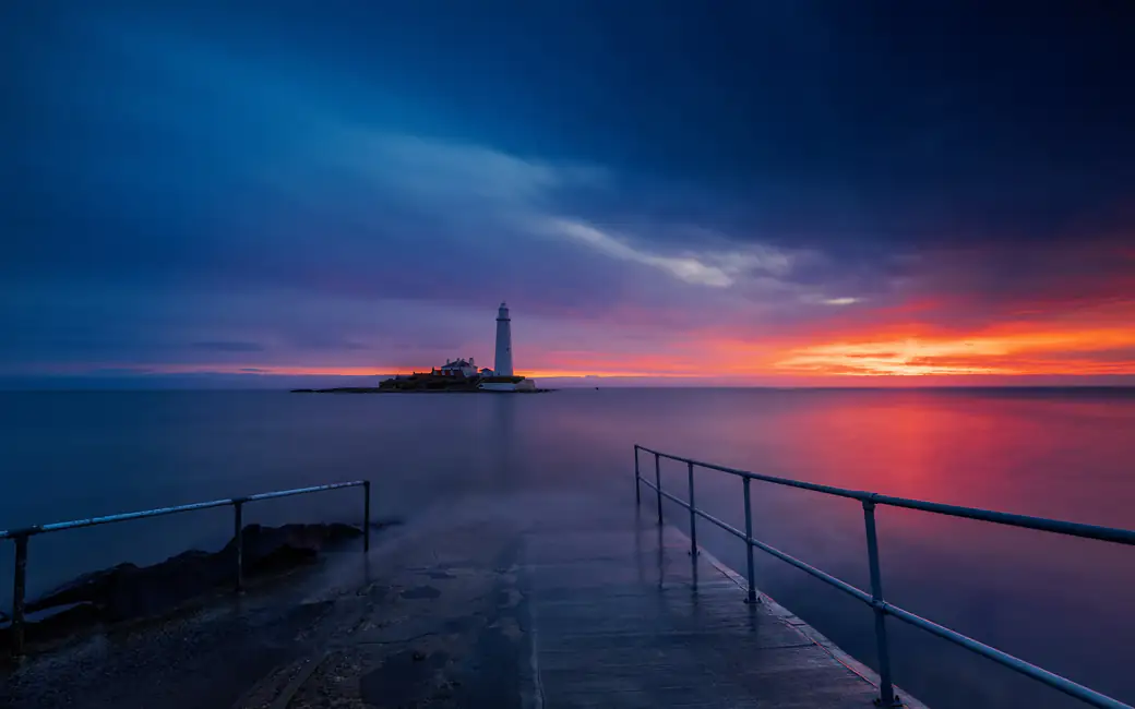 Lighthouse Over the Sunset Sea — desktop and phone wallpaper, free download